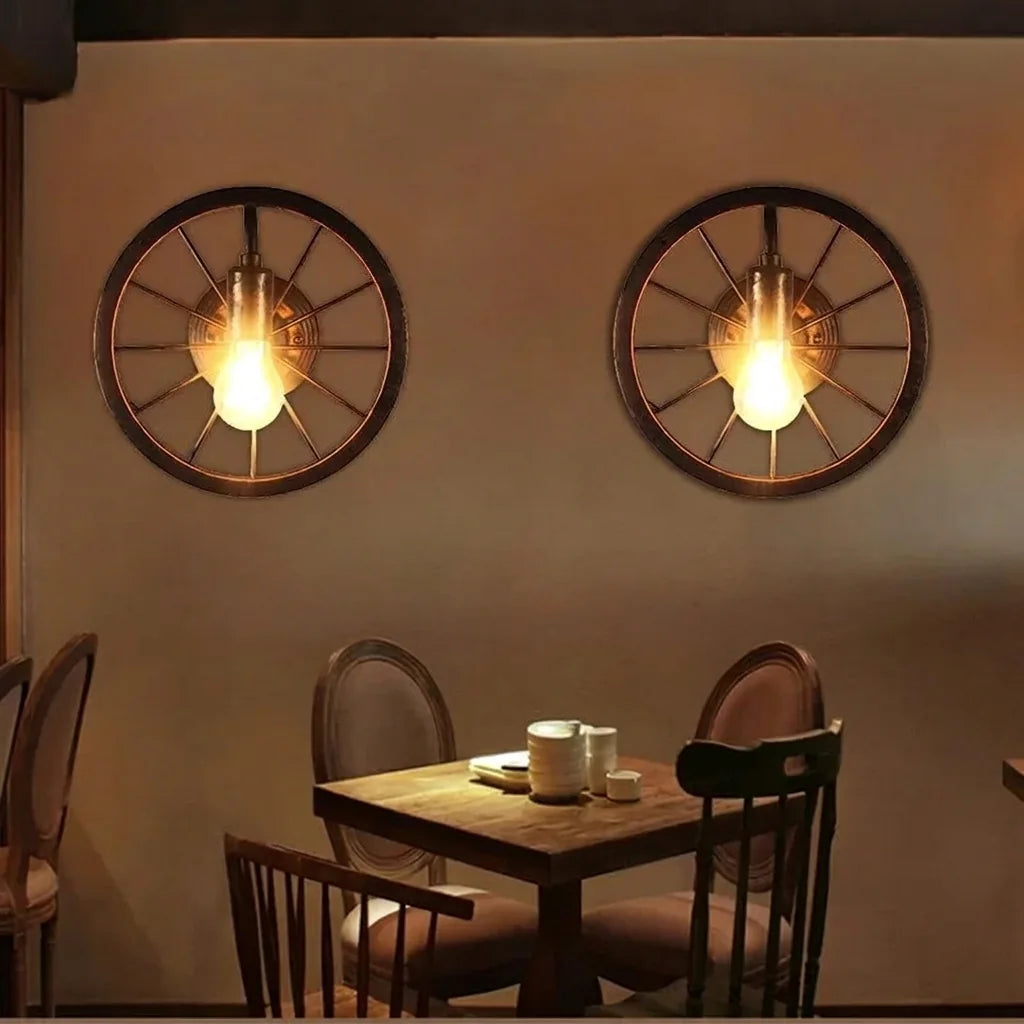 Deux appliques roue de charrette au-dessus d'une table de restaurant en bois