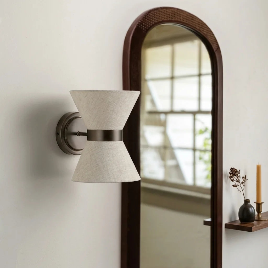 Applique sablier en lin près d'un miroir arche en bois foncé