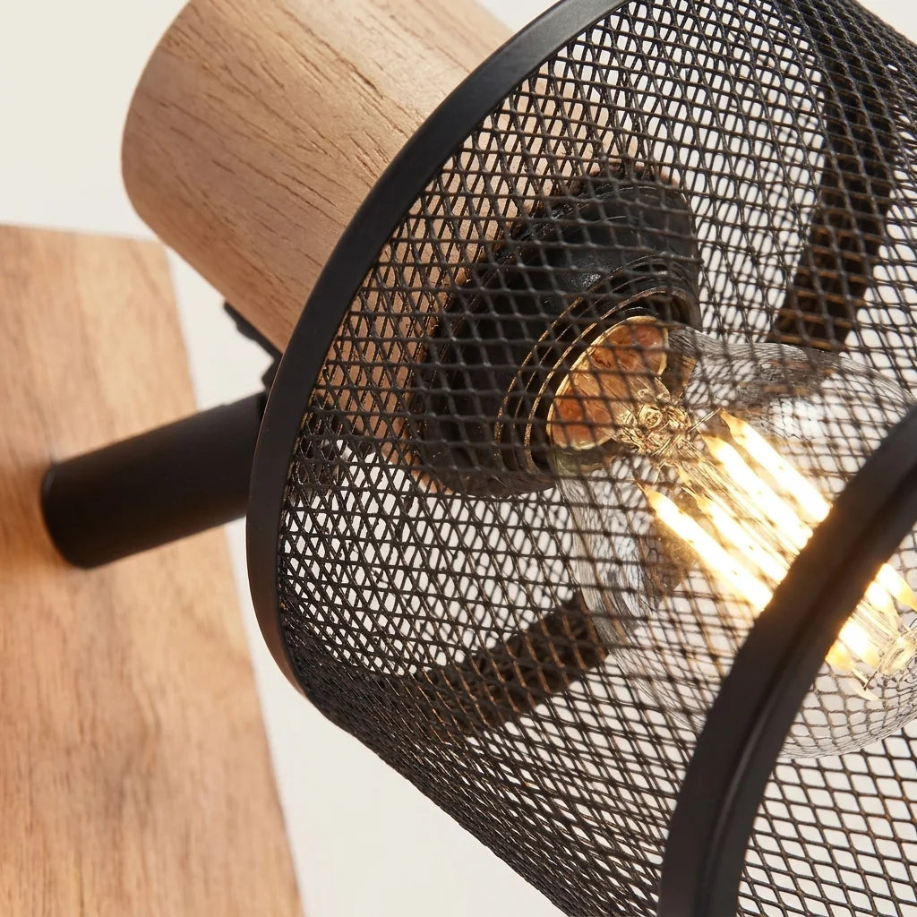 Abat-jour grillagé noir, ampoule filament et support en chêne vus de près