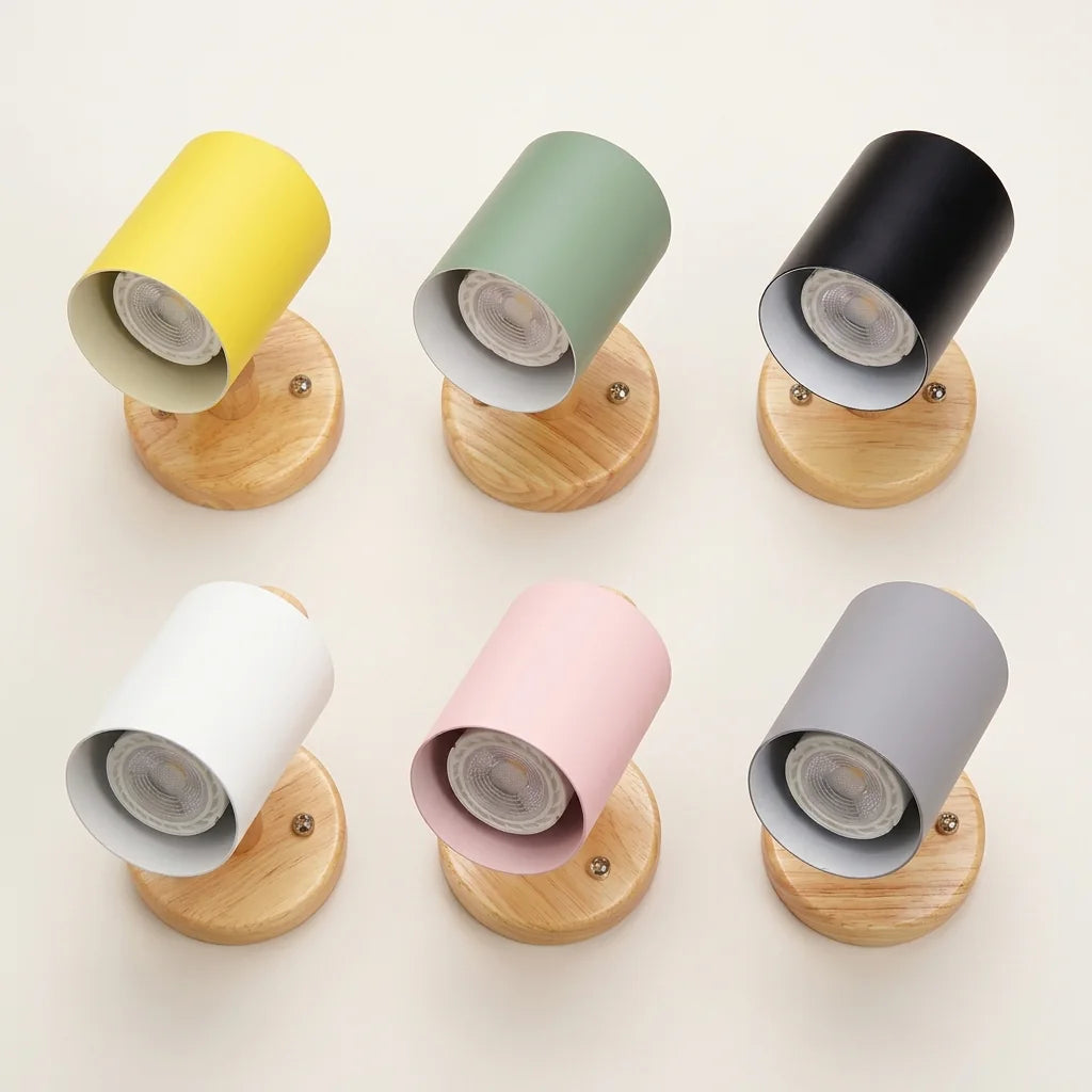Les six coloris de l'applique spot en bois : jaune, vert, noir, blanc, rose et gris
