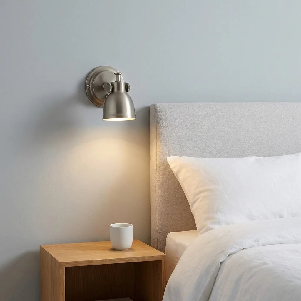 Applique spot cloche nickel au-dessus d'une tête de lit