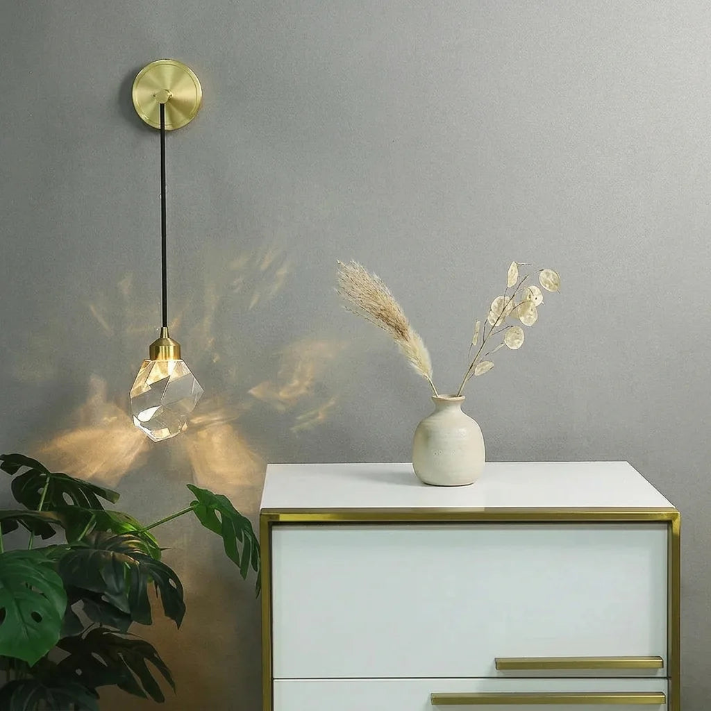 Applique en cristal suspendue au-dessus d'une commode blanche et dorée