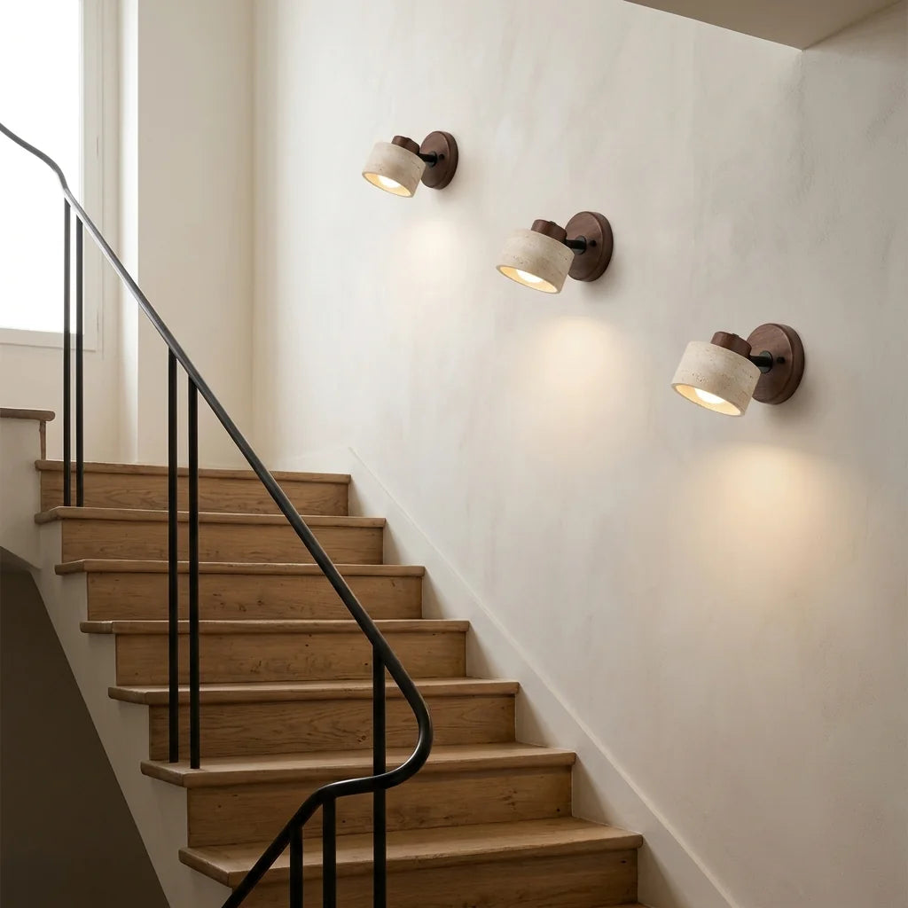Trois appliques en travertin et noyer le long d'un escalier en chêne