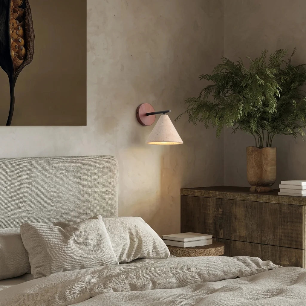 Applique en travertin au-dessus d'un lit en lin, mur à la chaux