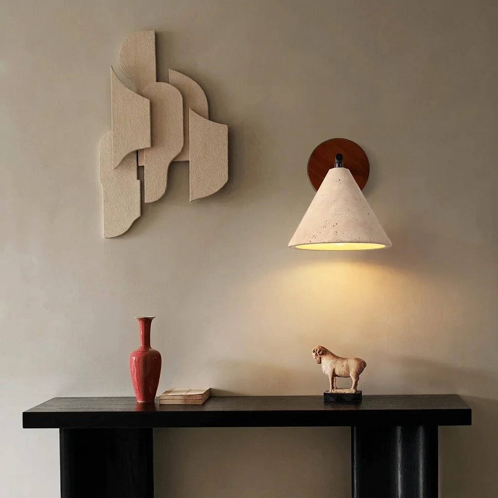 Applique en travertin au-dessus d'une console noire, vase rouge