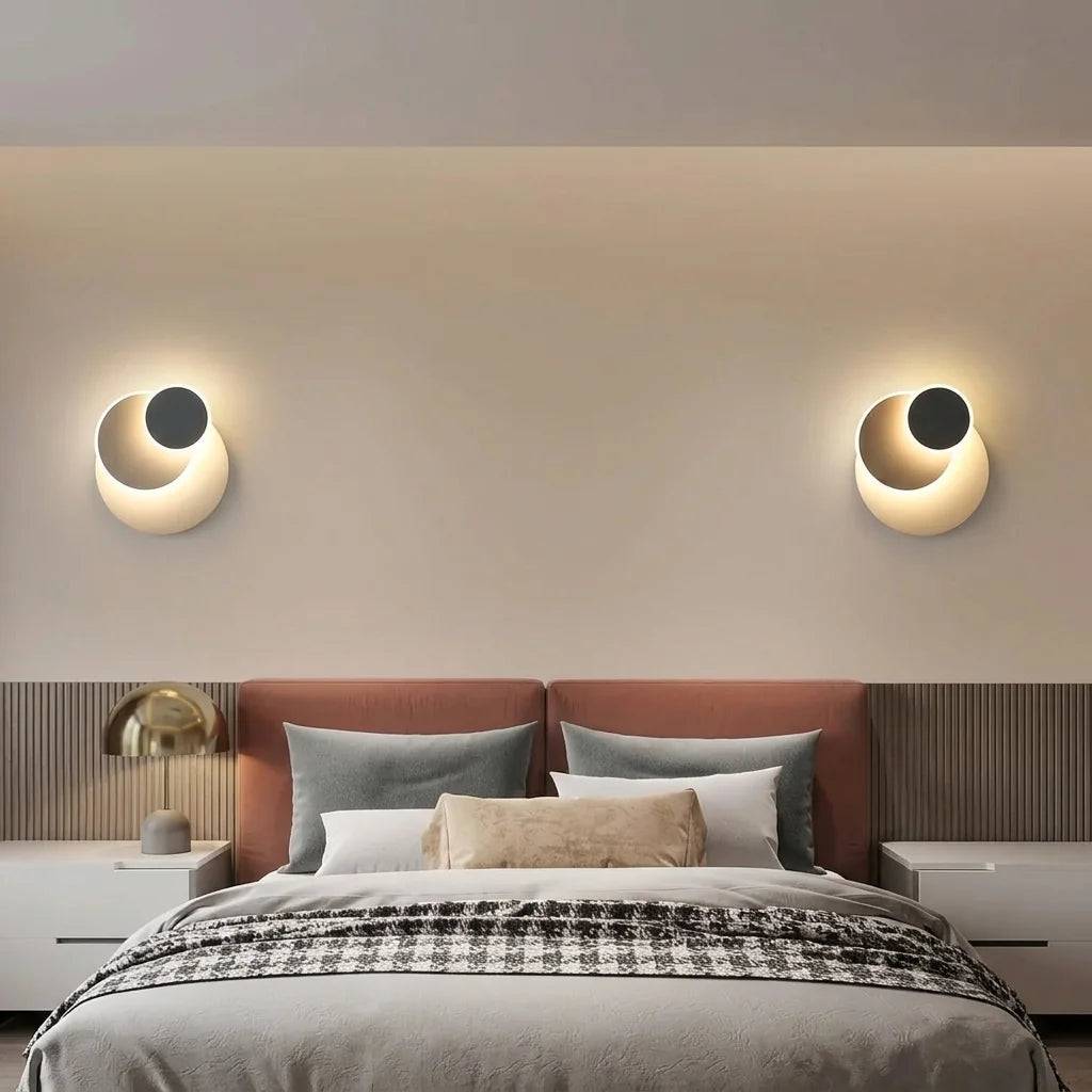 Deux appliques à trois disques au-dessus d'une tête de lit terracotta