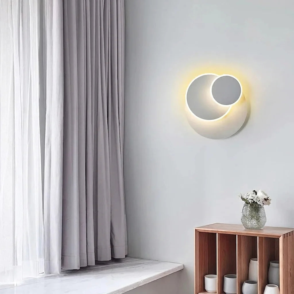 Applique à trois disques sur un mur gris près d'une fenêtre