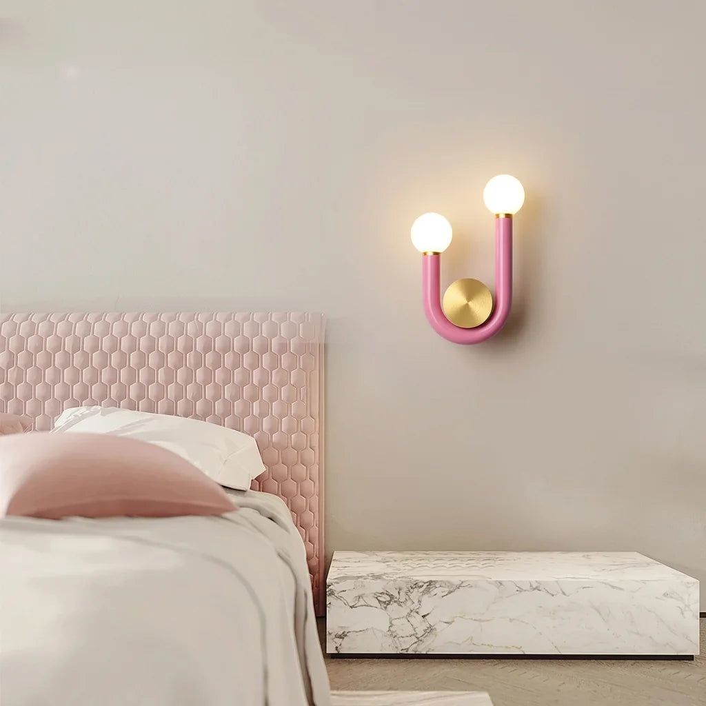 Applique en U rose au-dessus d'une tête de lit capitonnée rose