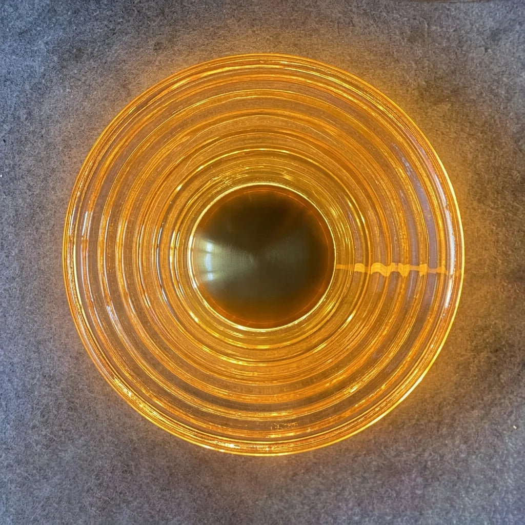 Détail du verre ambré strié éclairé et du centre en laiton