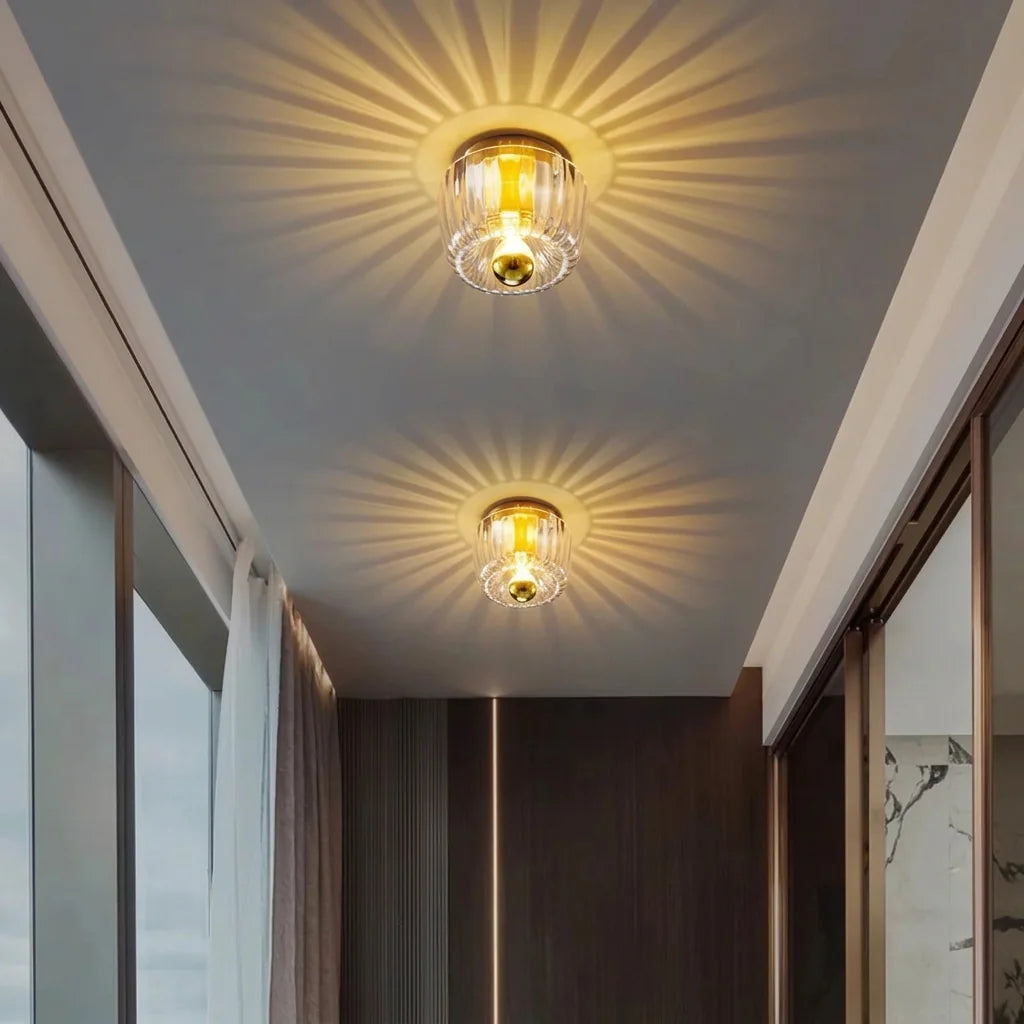 Deux lampes en verre cannelé projetant des rayons au plafond d'un couloir