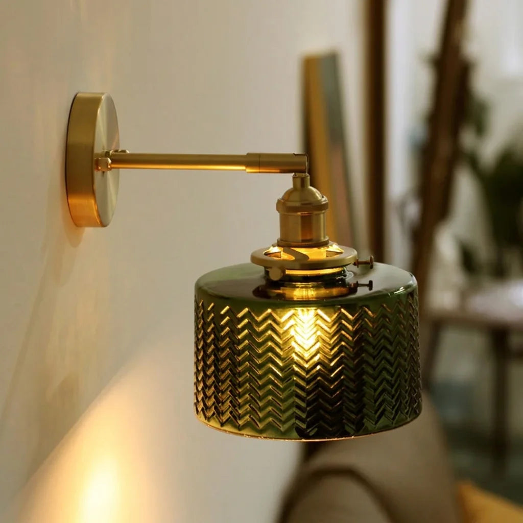 Applique en verre vert ciselé allumée dans un salon chaleureux