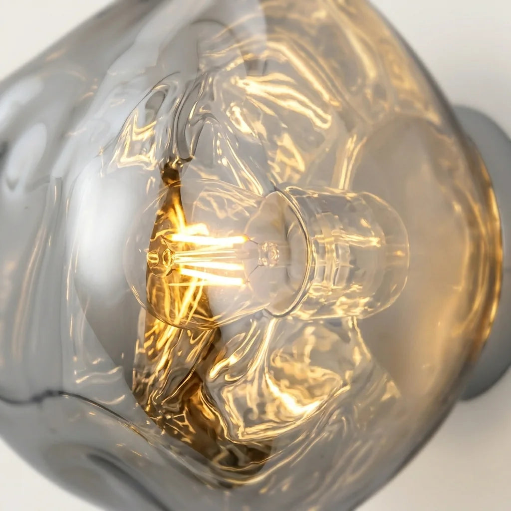 Reflets du verre soufflé et ampoule à filament de l'applique vus de près