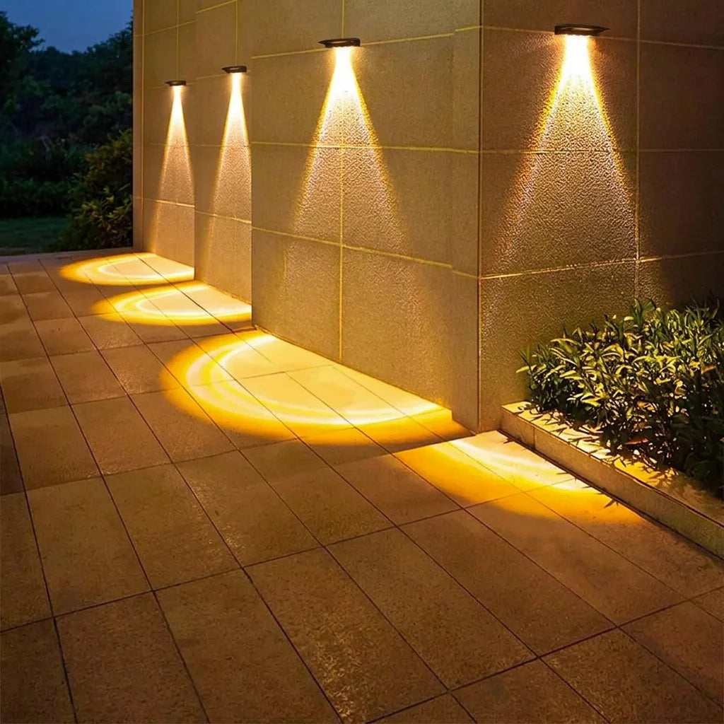 Appliques solaires éclairant un mur de terrasse et le dallage la nuit