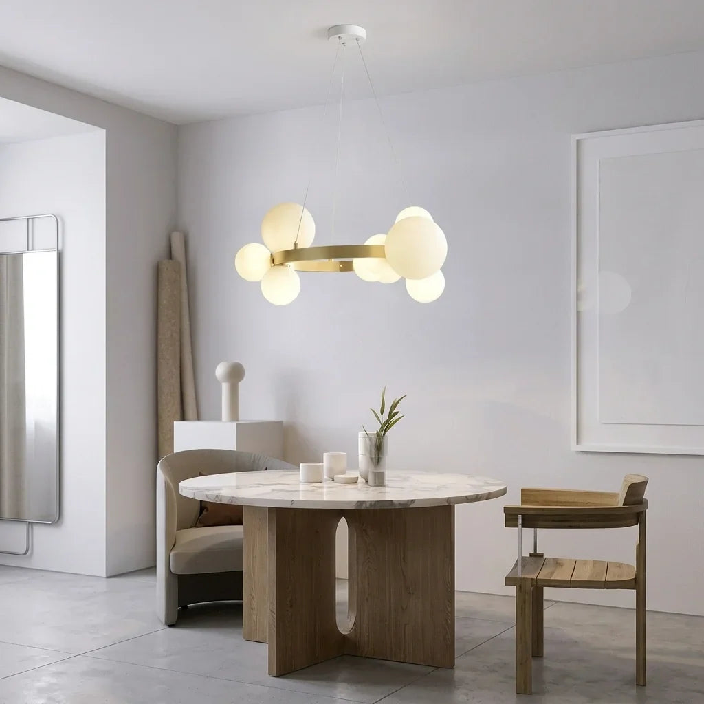 Lustre anneau à globes de verre au-dessus d’une table en marbre