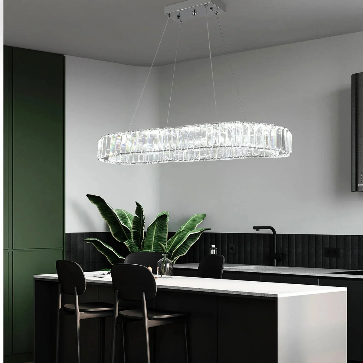 Lustre ovale en cristal au-dessus d’un îlot de cuisine vert