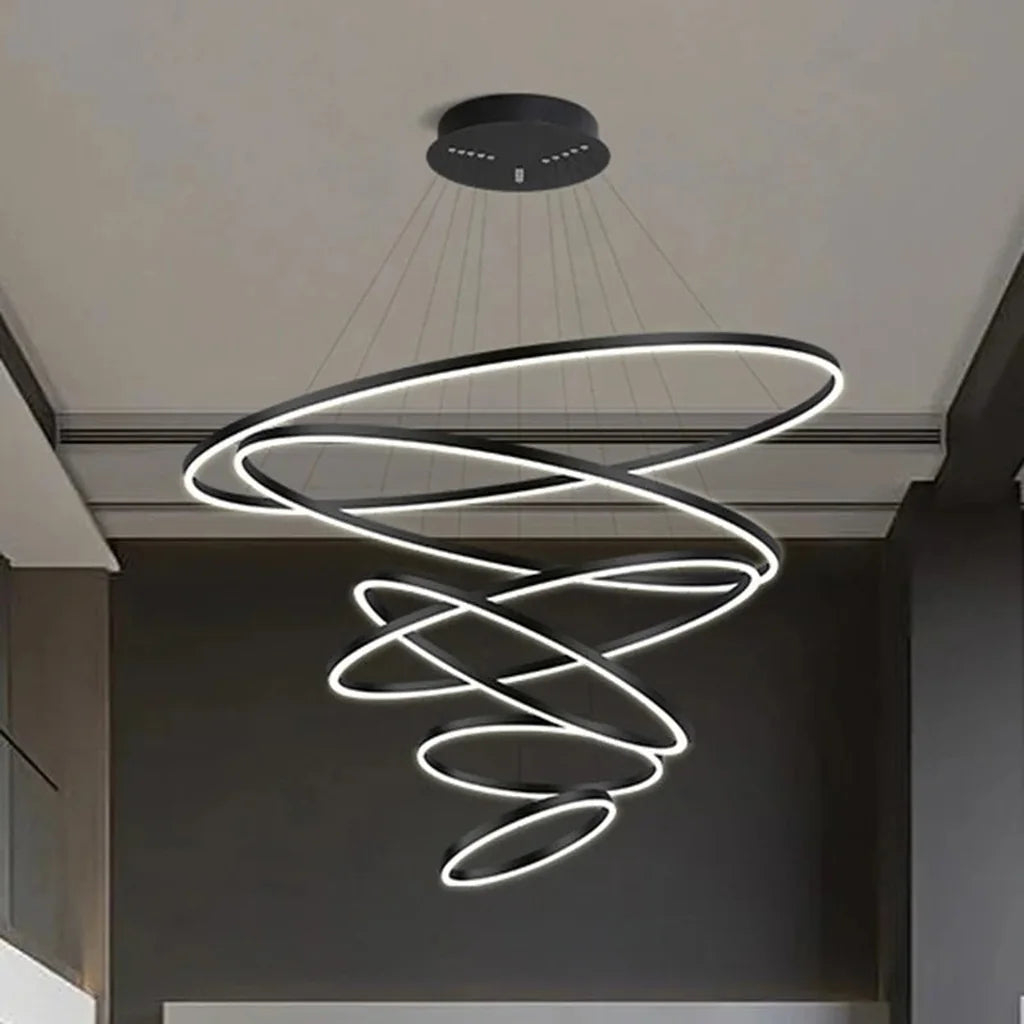 Lustre à anneaux LED noir dans une cage d’escalier