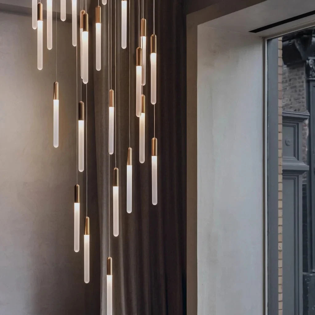 Lustre cascade LED dans une cage d’escalier près d’une grande fenêtre