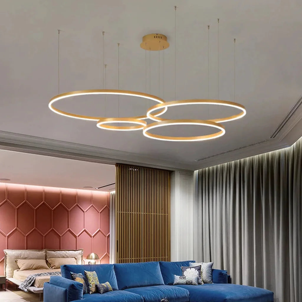 Lustre à anneaux doré au-dessus d'un canapé bleu dans un salon