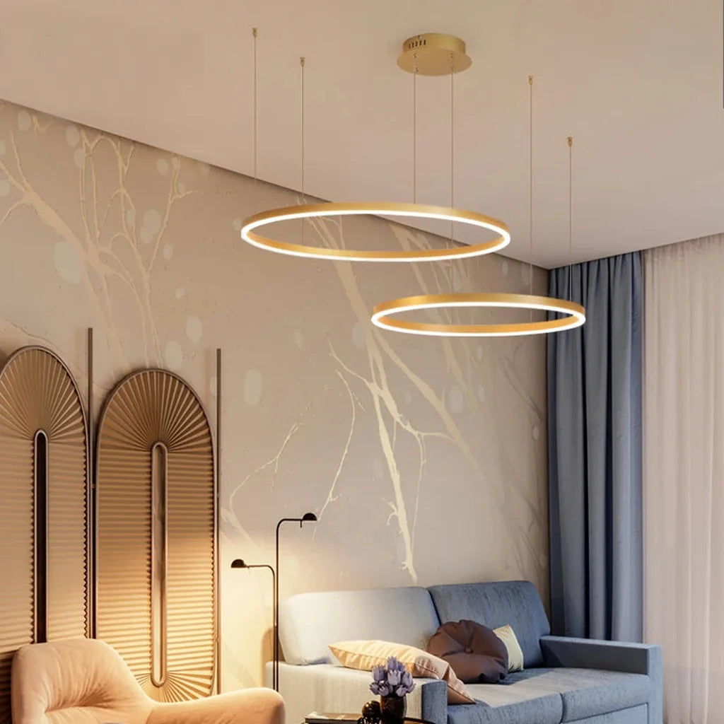 Lustre doré à deux anneaux dans un séjour aux tons clairs