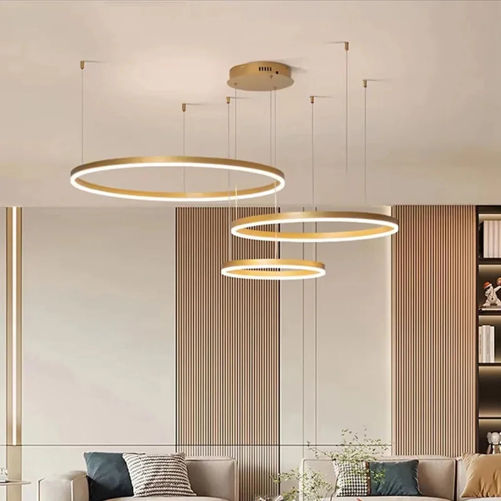 Lustre à anneaux doré dans un salon lumineux