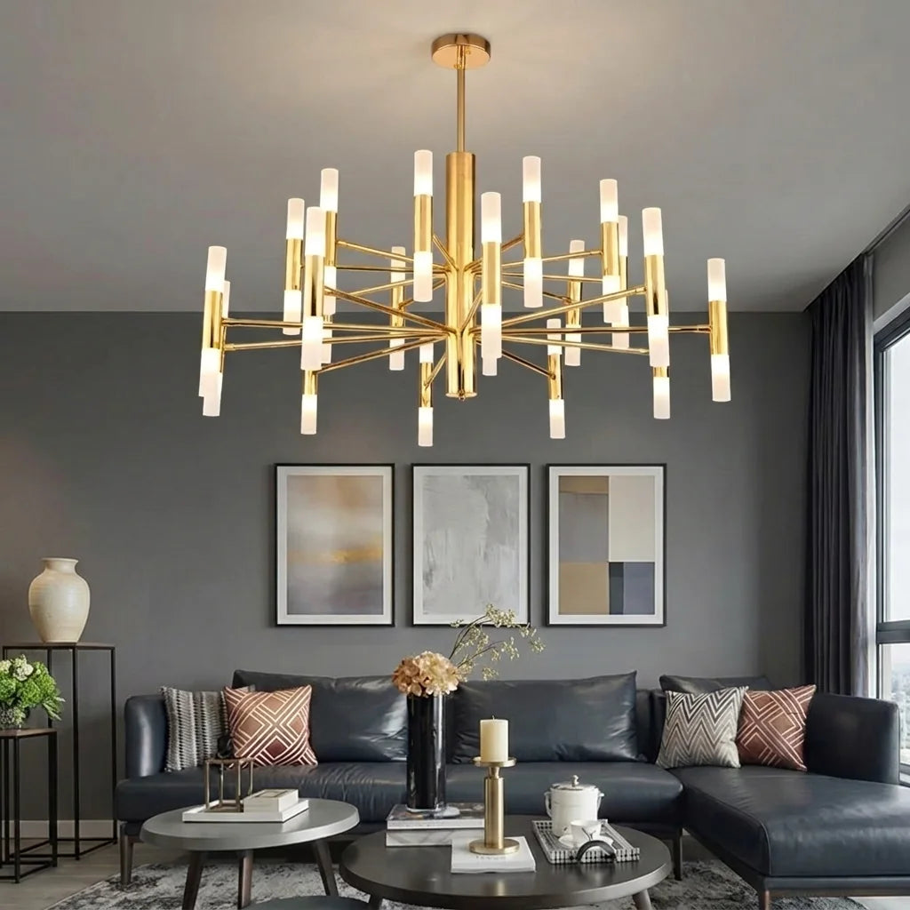 Lustre doré à tubes dans un salon gris avec canapé en cuir