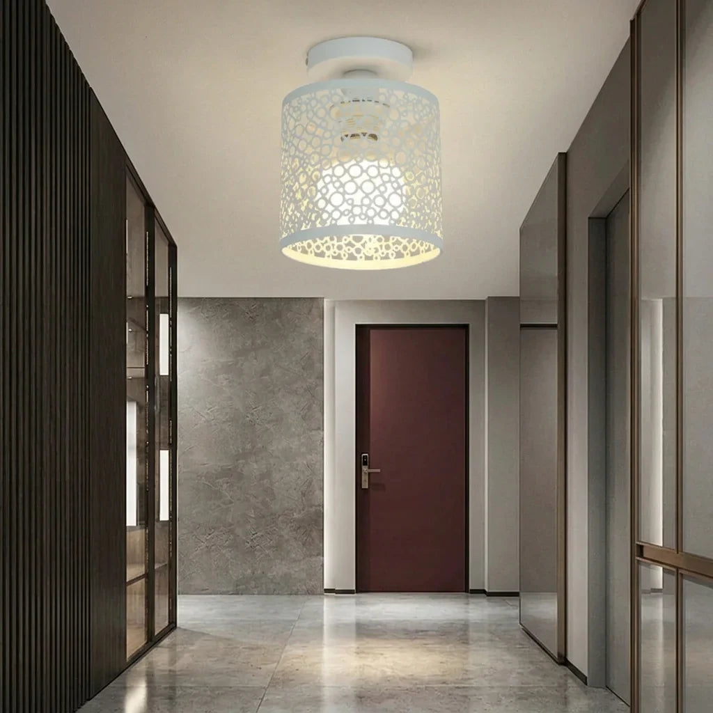 Plafonnier ajouré blanc dans un couloir aux murs de marbre