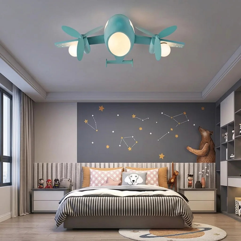Plafonnier avion bleu dans une chambre d’enfant au mur étoilé