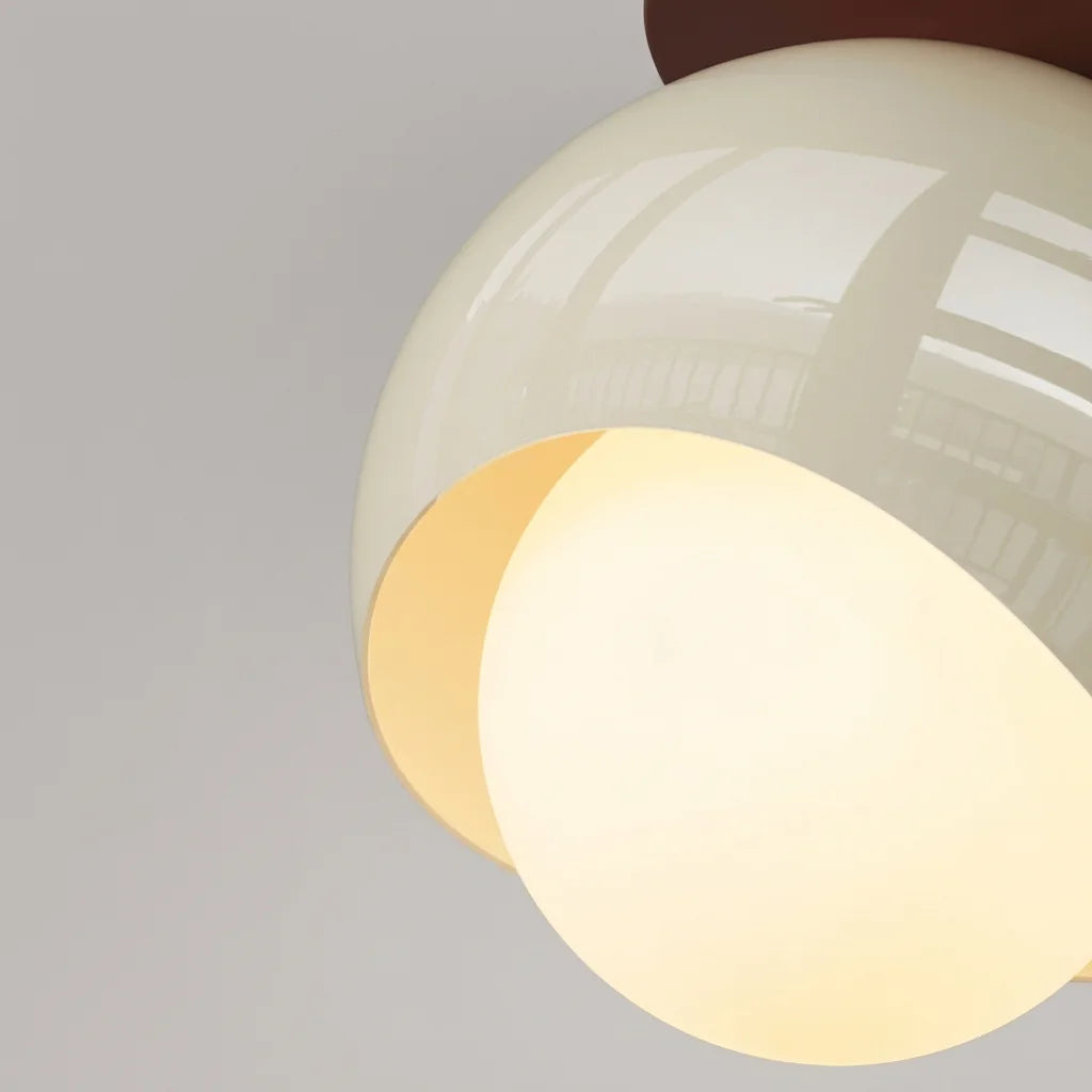 Abat-jour en métal brillant et globe en verre opalin vus de près