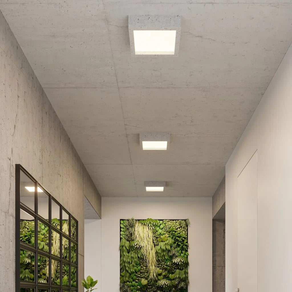 Plafonnier carré béton et verre blanc dans un couloir