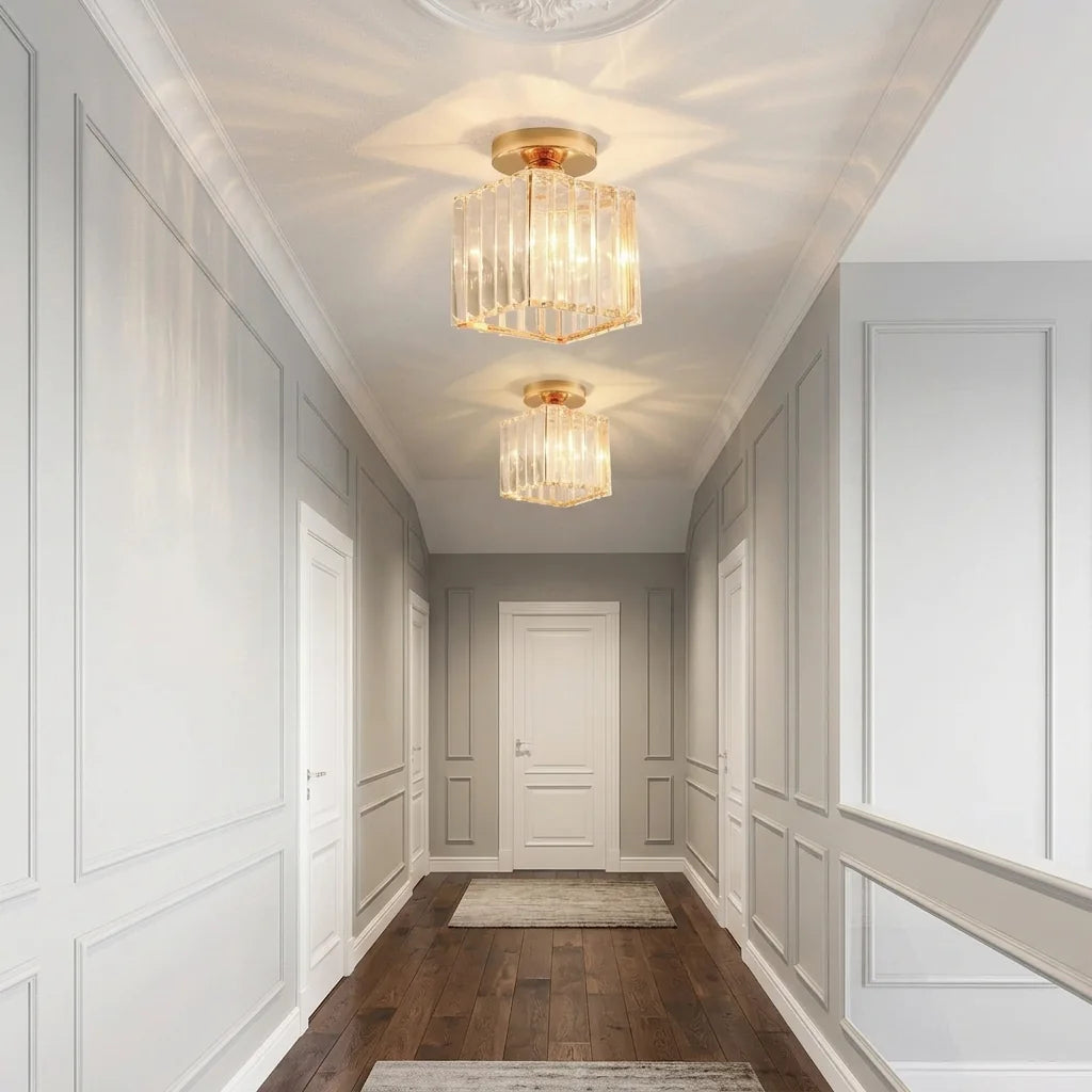 Deux plafonniers cristal dorés dans un couloir à moulures