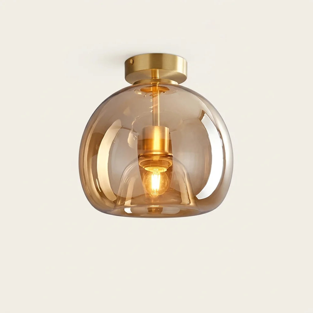 Plafonnier globe en verre cognac contre le plafond, rosace laiton