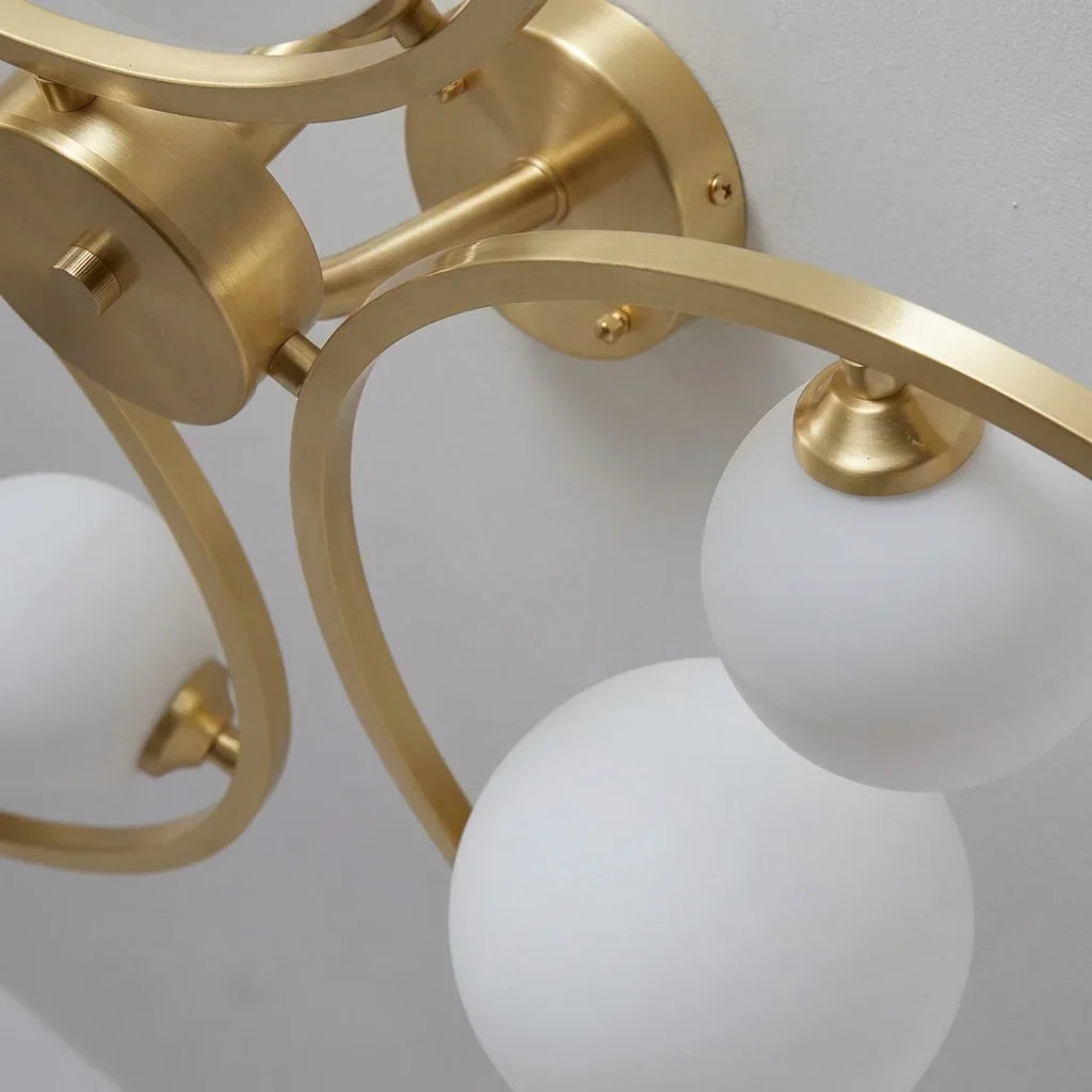 Arcs en laiton et globes en verre opalin en gros plan