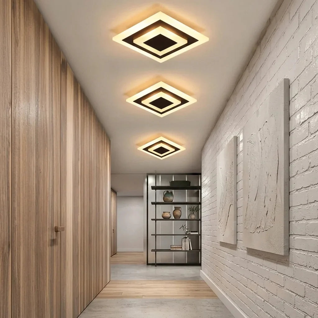 Trois plafonniers carrés dans un couloir bois et brique