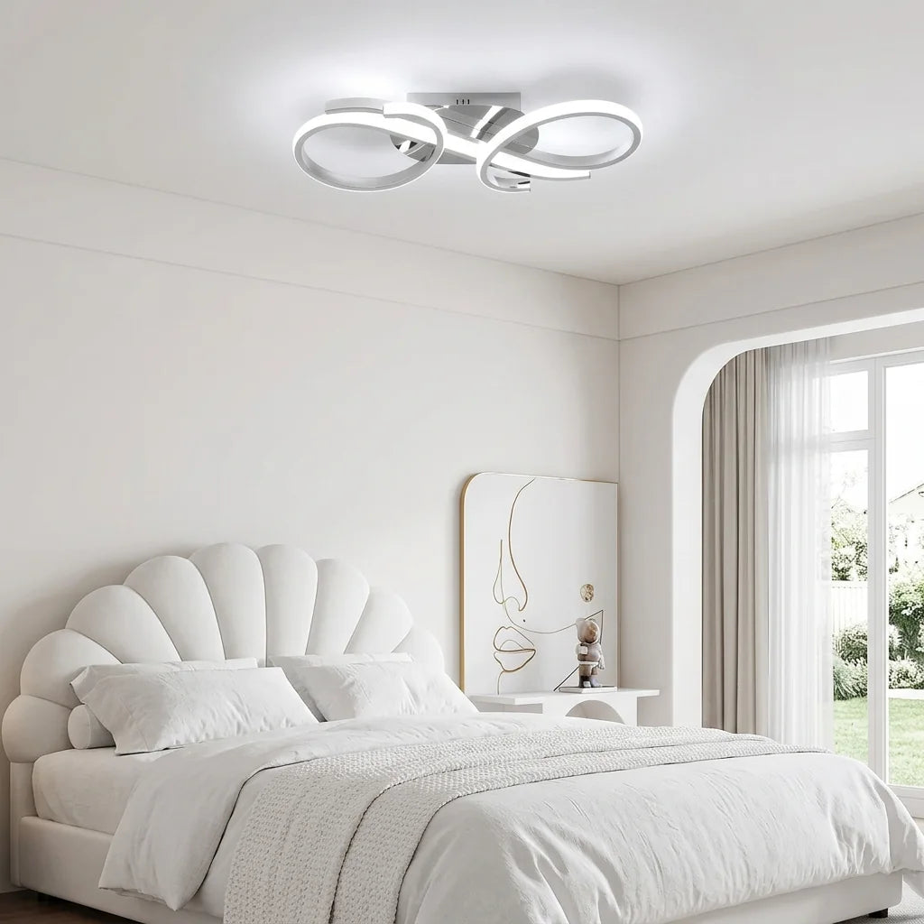 Plafonnier LED blanc à boucles au-dessus d’un lit