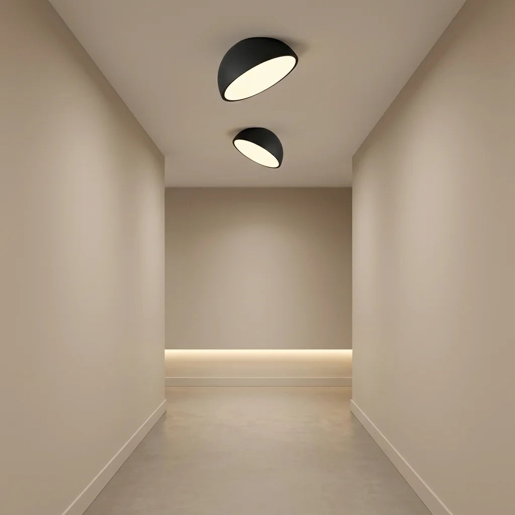 Deux plafonniers demi-sphère noirs dans un couloir clair