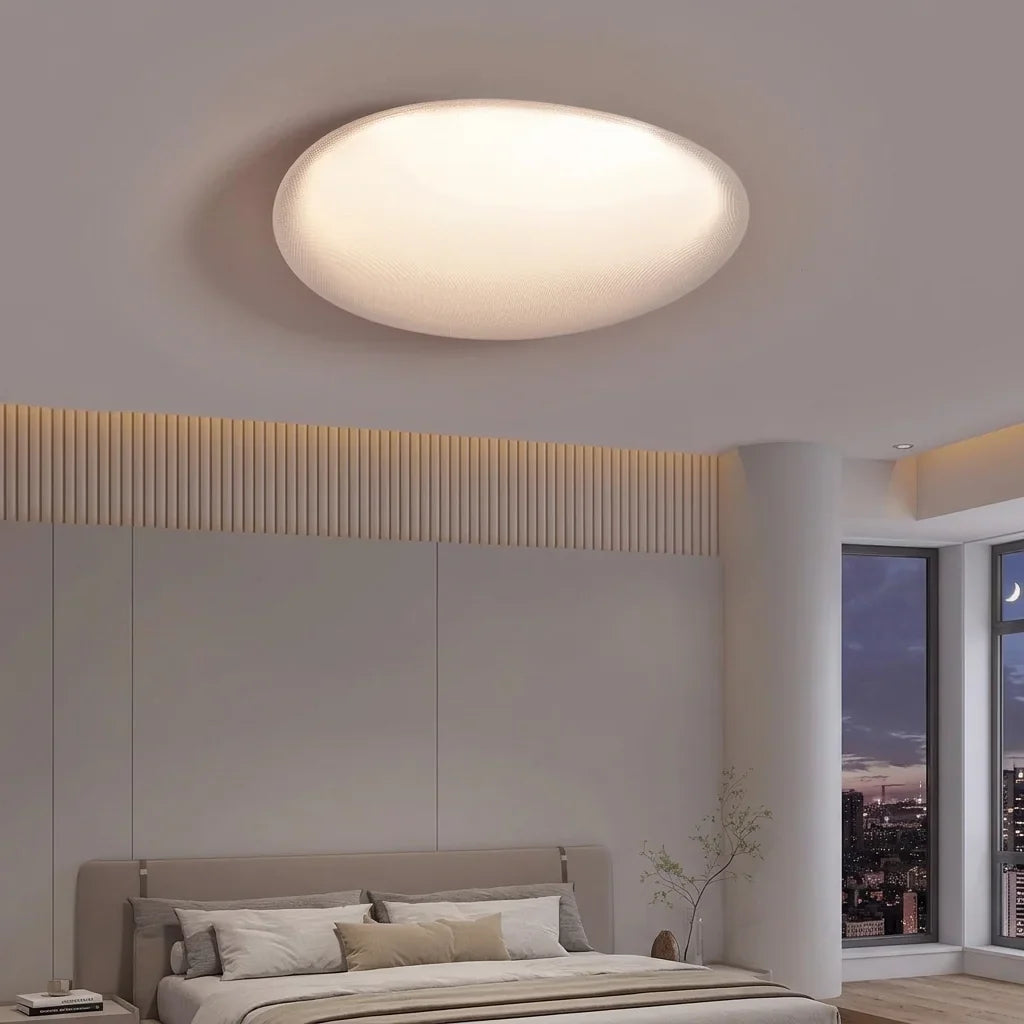 Plafonnier LED galet ovale dans une chambre moderne