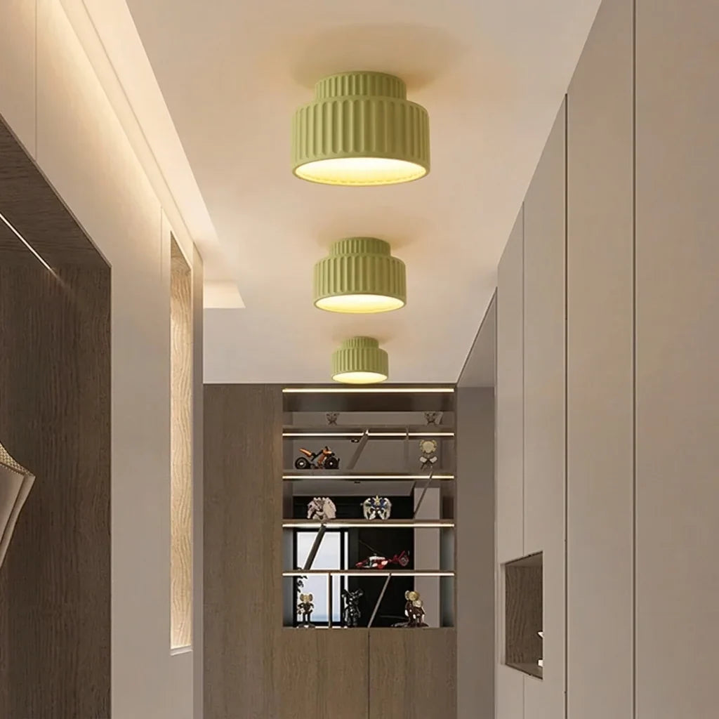 Trois plafonniers verts nervurés au plafond d’un couloir