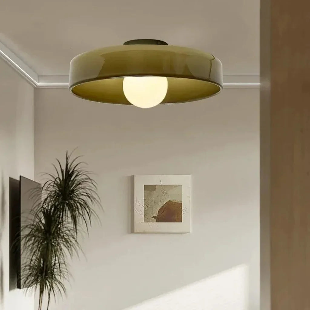 Plafonnier en verre vert dans un salon aux murs beiges
