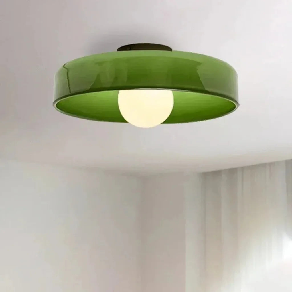 Plafonnier en verre vert allumé dans une pièce claire