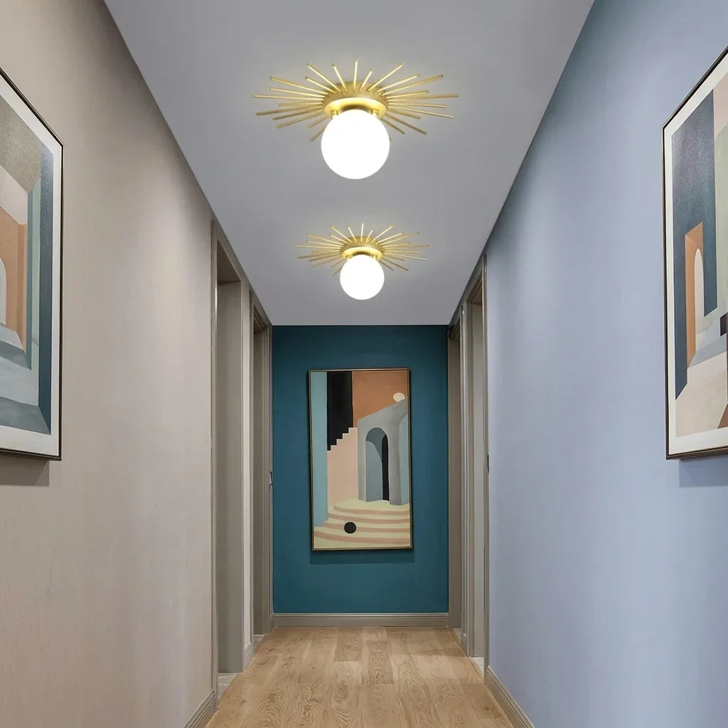 Deux plafonniers soleil dorés dans un couloir aux murs colorés