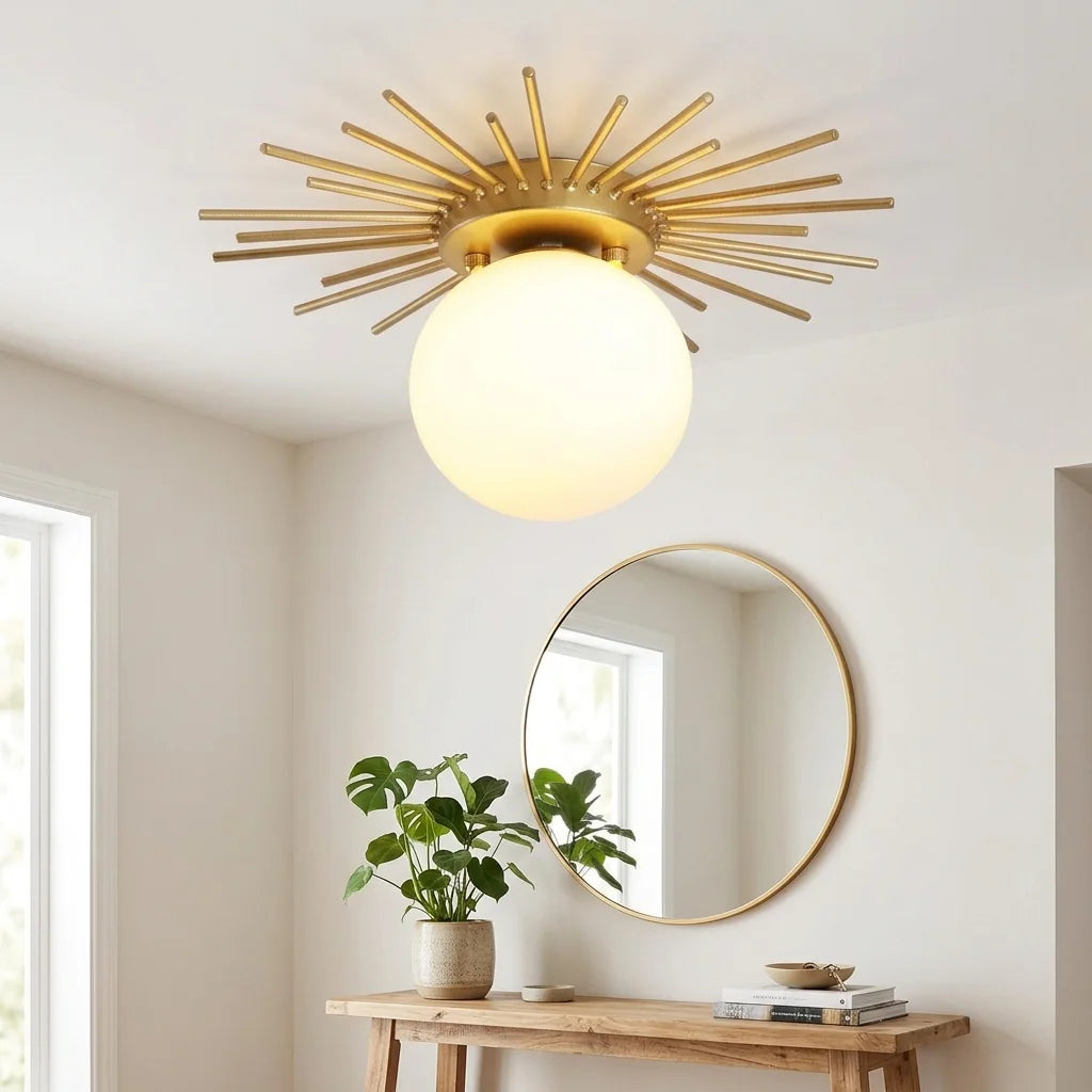 Plafonnier soleil doré dans une entrée claire avec miroir rond