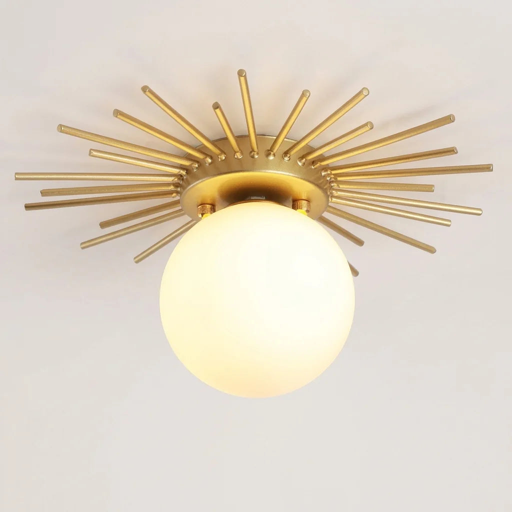Plafonnier soleil à rayons dorés et globe en verre opale, allumé