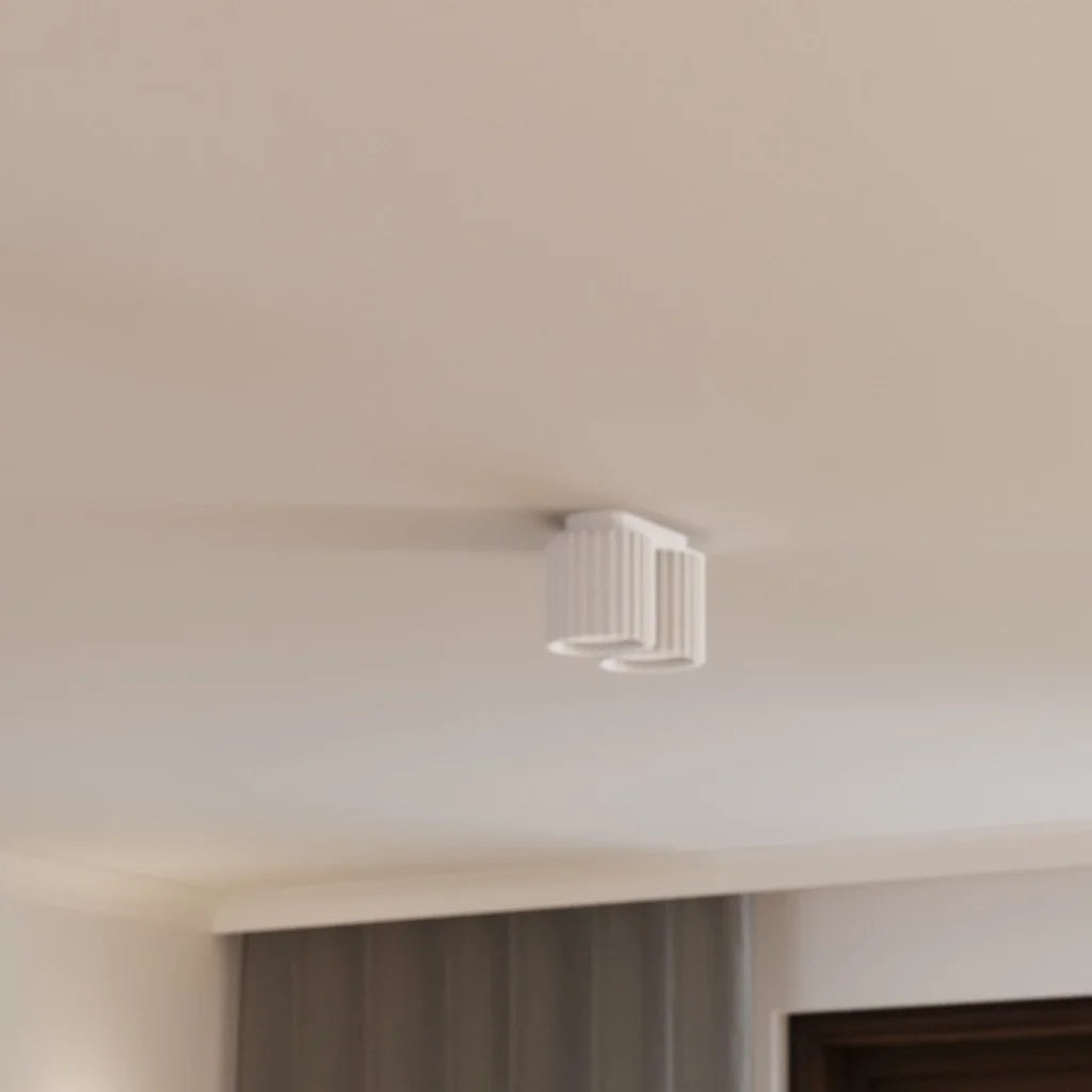 Plafonnier spots cylindres cannelés dans une chambre