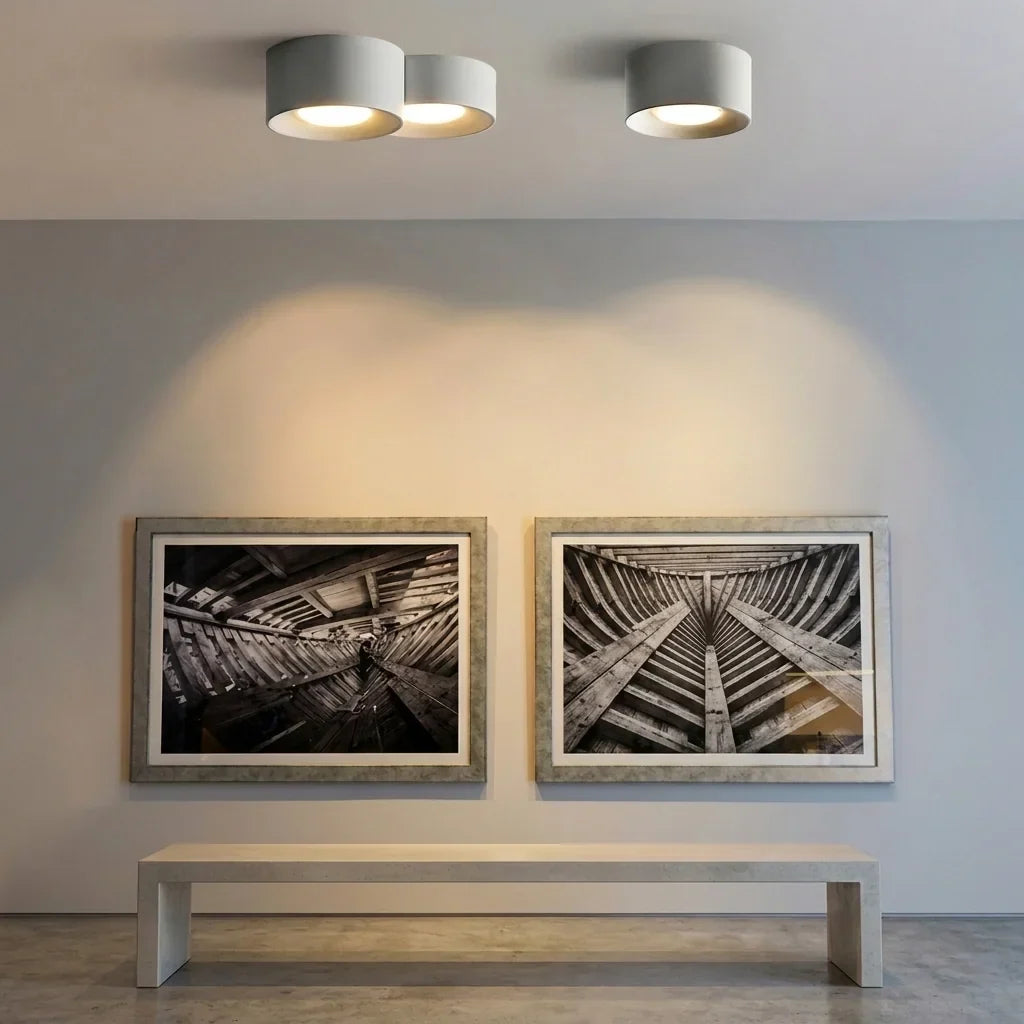 Spots LED blancs au-dessus d’un mur de tableaux
