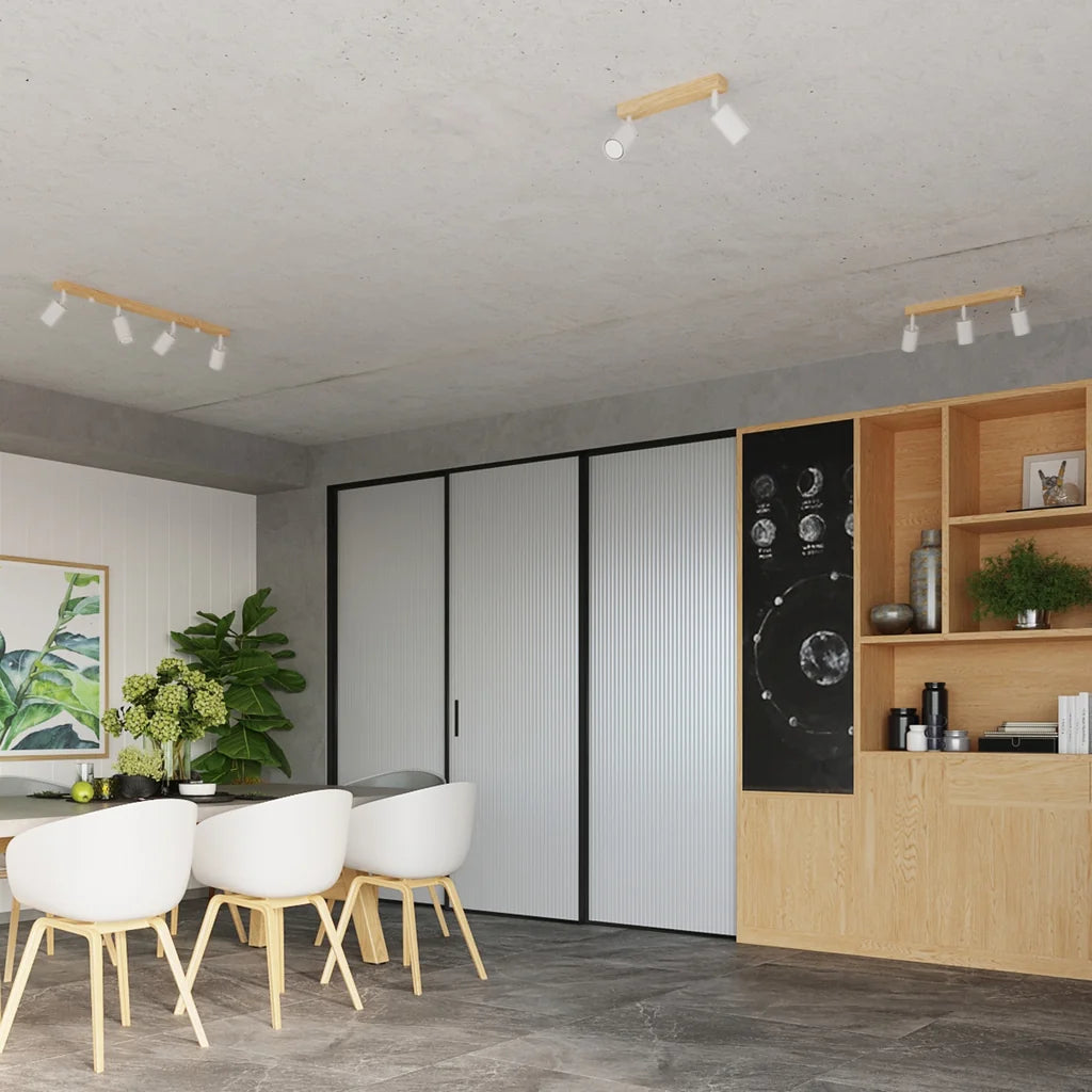 Plafonnier spots orientables sur barre en bois dans une salle à manger