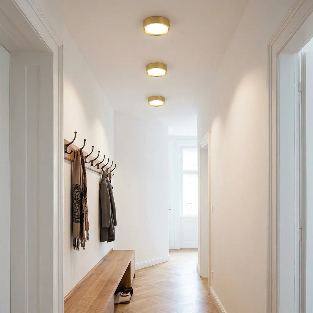 Spots LED ronds dorés au plafond d’une entrée lumineuse