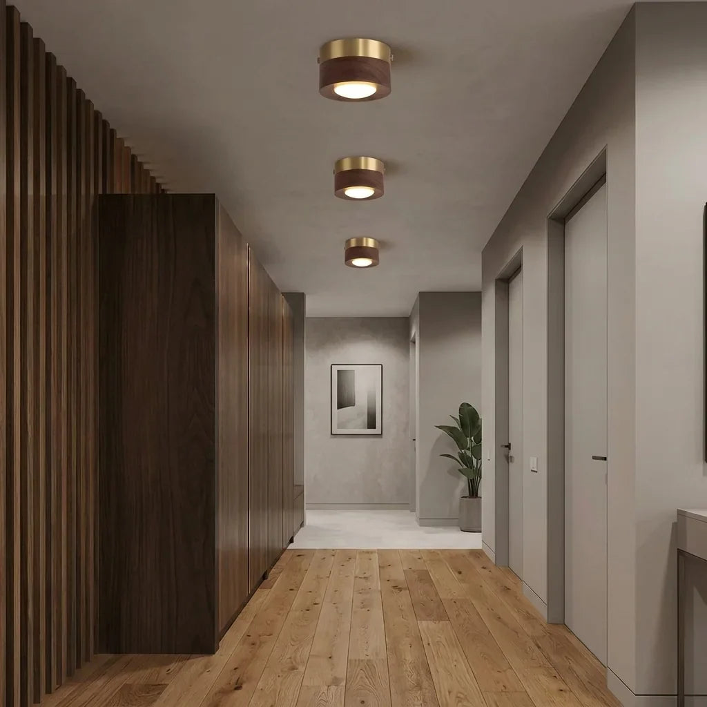 Spots noyer et laiton alignés dans un couloir moderne
