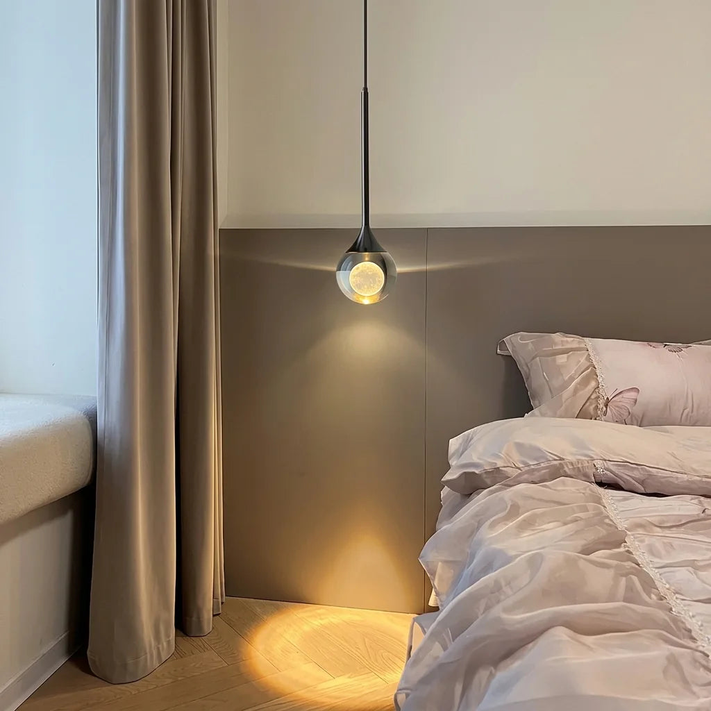 Suspension boule lune allumée à côté d’un lit, lumière chaude