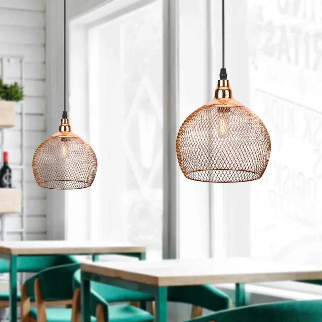 Suspensions cages grillagées or rose dans un café