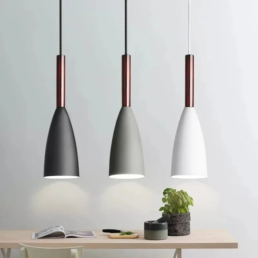 Trio de suspensions cône noire, grise et blanche au-dessus d’une table